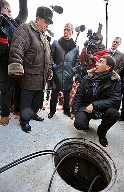 Глава Новгородского района Анатолий Швецов (второй слева), губернатор Новгородской области Сергей Митин (в центре) и министр связи и массовых коммуникаций России Игорь Щеголев (справа) наблюдают за прокладкой волоконно-оптического кабеля для обеспечения круглосуточной онлайн-трансляции выборов президента России 
