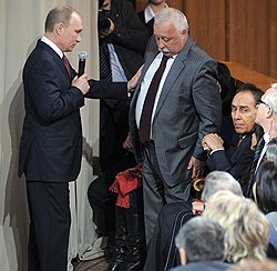 Телеведущий Леонид Якубович (в центре), художественный руководитель Московского музыкально-драматического цыганского театра "Ромэн" Николай Сличенко (второй справа) во время встречи председателя правительства, кандидата в президенты России Владимира Путина (слева) со своими доверенными лицами. Встреча прошла в Политехническом музее 