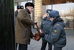 Сотрудники правоохранительных органов проводят досмотр сопредседатель оппозиционной Партии народной свободы (ПАРНАС) Владимира Рыжкова (слева) перед митингом "За честные выборы", организованном активистами движения "Левый фронт" на Новом Арбате 