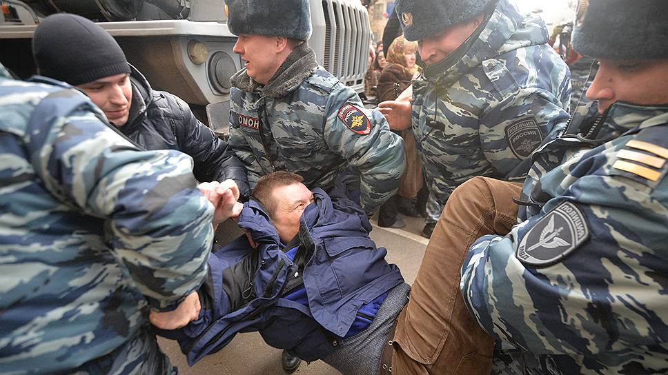 Сотрудники правоохранительных органов во время задержания полицией (ОМОН) одного из тех, кто пришел к зданию суда поддержать обвиняемых восьми фигурантов дела о беспорядках на Болотной площади 6 мая 2012 года, у Замоскворецкого суда 