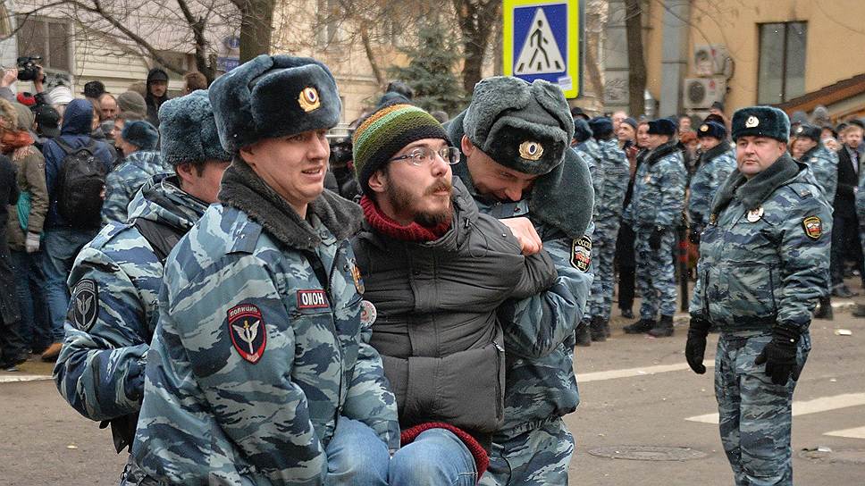 Сотрудники правоохранительных органов во время задержания полицией (ОМОН) одного из тех, кто пришел к зданию суда поддержать обвиняемых восьми фигурантов дела о беспорядках на Болотной площади 6 мая 2012 года, у Замоскворецкого суда 