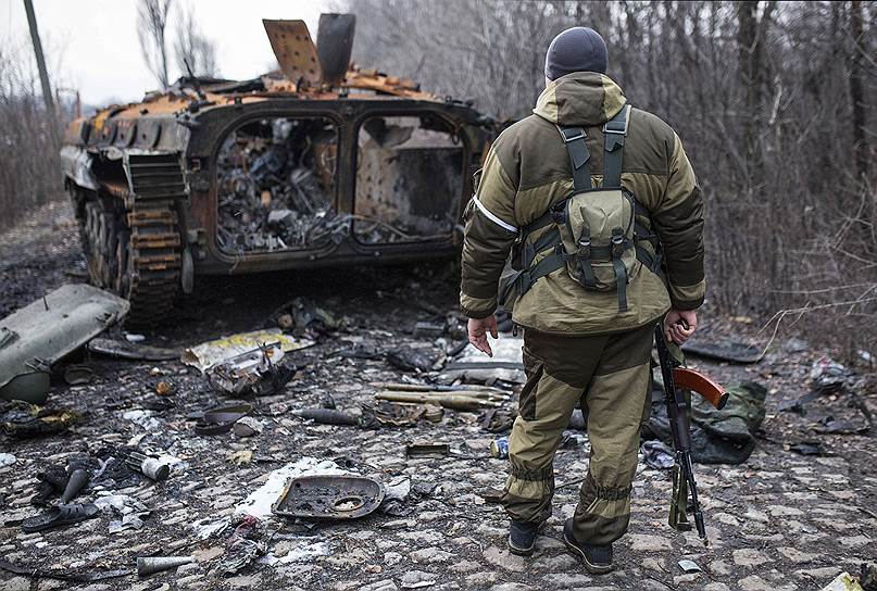 Вокруг подбитой машины раскиданы бронежилеты, помятые каски, ветви кустарника вдоль дороги все посечены пулями. Стоит сгоревший танк