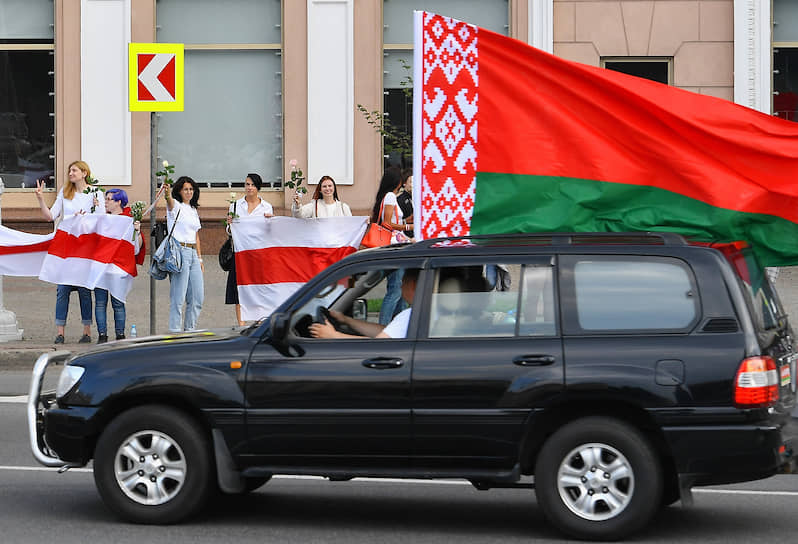 На улицах Минска в пятницу развернулась «война флагов»: сторонники Александра Лукашенко ездили с красно-зелеными, оппозиционеры стояли в цепи с бело-красно-белыми 