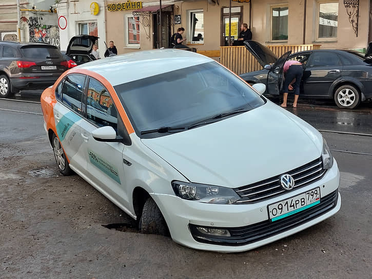«Делимобиль», провалившийся в промоину асфальта после сильного ливня в Москве 
