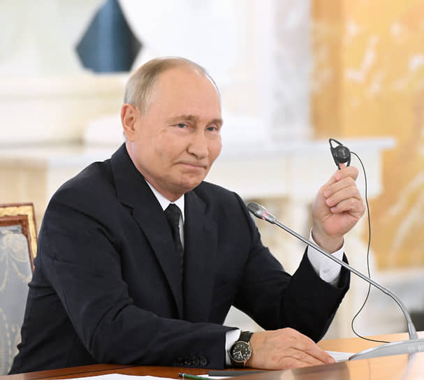 Президент России Владимир Путин объясняет участникам встречи, как они его услышат 
