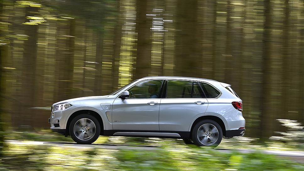 Правильное название модели — BMW X5 xDrive40e. Этот полноприводный кроссовер оснащен двумя моторами: двухлитровым бензиновым, установленным под капотом, и электрическим, встроенным в корпус автоматической коробки передач. Небольшая батарея спрятана под полом багажника, ее энергии хватает километров на 30, если использовать только электротягу; в гибридном режиме запас хода составляет около 830 км