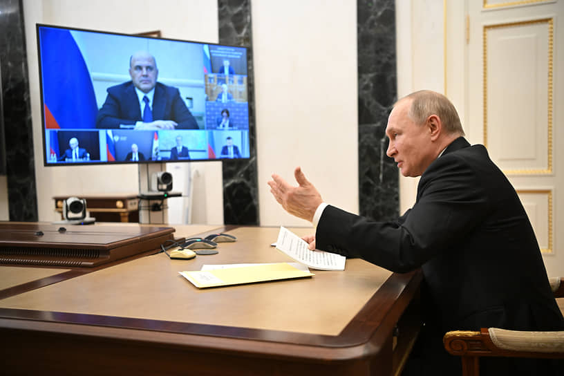 Премьер-министр России Михаил Мишустин (на экране) и президент Владимир Путин 