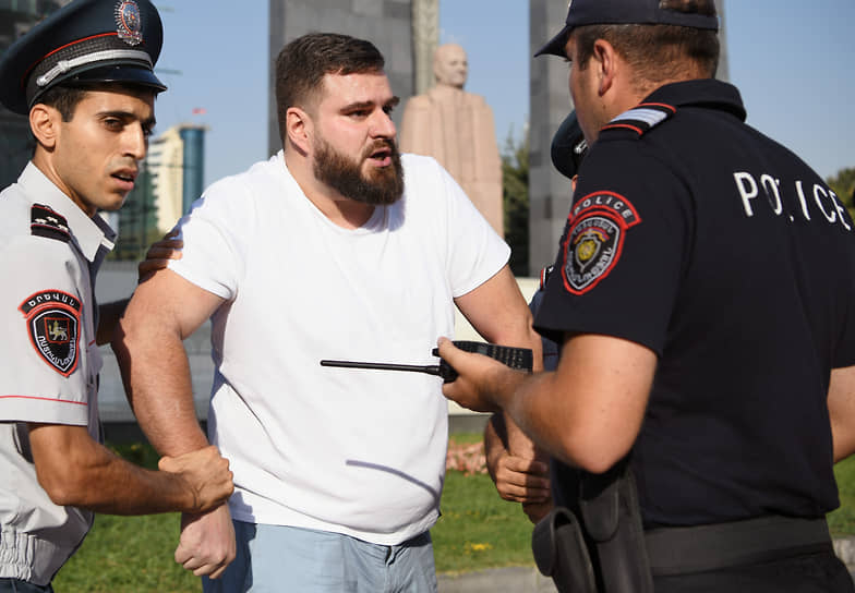 Микаэл Бадалян (в центре) во время задержания на митинге в Ереване в июле 2022 года 