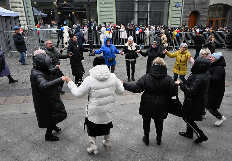 Хоровод на Кузнецком мосту в Москве на фоне очереди в посольство Молдавии 