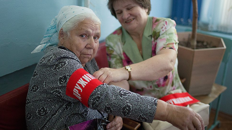 Всеобщая "дочка", 65-летняя Зинаида Парфенова (справа) экипирует патруль перед выходом