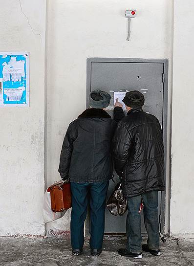 Двое пожилых мужчин у входа в общественную баню, которая работает только по выходным 