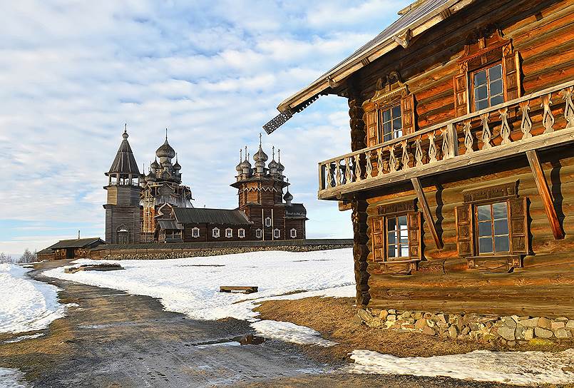 Вид на Кижский погост со стороны дома Ошевнева. Главную достопримечательность — церковь Преображения Господня (на заднем плане) — реставрируют уже не первый год. Часть главок разобрана, и вся конструкция держится на металлическом каркасе. Зато зимний Покровский храм предстает во всей красе 