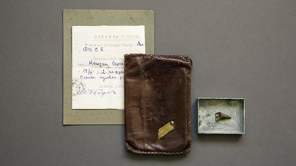 Справка о ранении от 14 сентября 1942 года. То самое кожаное портмоне с памятной гравировкой, пробитое осколком снаряда. Рядом часть второго осколка разорвавшегося снаряда, который попал в ногу 