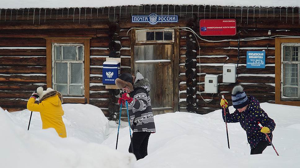 Во время урока физкультуры дети катаются на лыжах по деревне