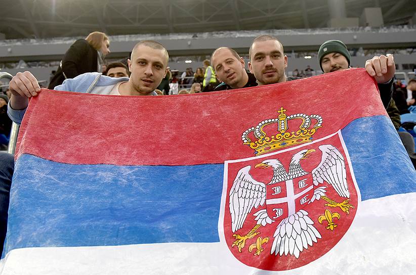 Сербы-болельщики сербской футбольной команды "Црвена Звезда" с государственным флагом Сербии 