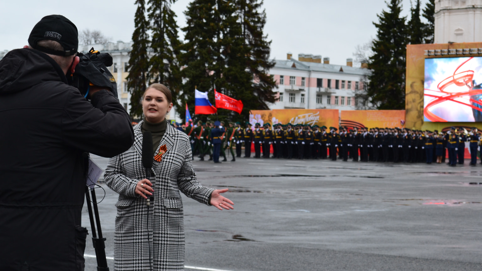 Запись сюжета для телеканала на фоне выстроенных парадных коробок.