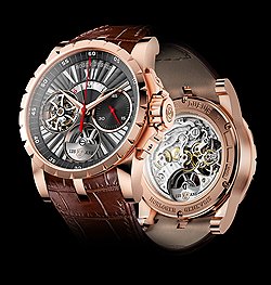 Roger Dubuis Excalibur Tourbillon volant Chronographe Mono-poussoir К юбилею Poincon de Geneve марка Roger Dubuis выпустила лимитированную серию часов Excalibur с однокнопочным хронографом и парящим турбийоном. "Женевское клеймо" и надпись "125 лет" проставлены на платиновом микророторе со стороны циферблата