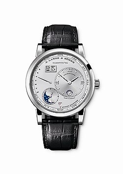 A. Lange & Sohne, Lange 1 Tourbillon Perpetual Calendar, 2012.  В модели Lange 1 объединены сразу две классические сложные функции. Мануфактурный механизм Lo82.1 с автоматическим заводом. Механизм изготовлен в соответствии с высокими стандартами качества саксонской мануфактуры, вручную декорирован и собран. Запас хода — 50 часов при полном подзаводе. Указание времени — часы, минуты, маленькая секундная стрелка. Турбийон с запатентованной функцией остановки при коррекции времени, вечный календарь с большим указателем даты и указателями дня недели, месяца, високосного цикла, индикатор "день/ночь", указатель фаз Луны. Корпус 41,9 мм в диаметре может быть изготовлен из розового золота или из платины (ограниченная серия в 100 штук) 