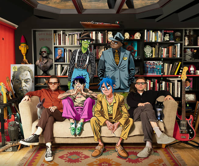 Gorillaz в 2020: Джейми Хьюлетт (слева) и Деймон Албарн с рисованными участниками группы Мардоком Никкалсом (стоит слева), Расселом Хоббсом (стоит справа), 2D (сидит справа) и Нудлом (сидит слева) 