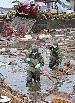 16 марта. Силы самообороны ищут погибших в городе Натори, префектура Мияги 