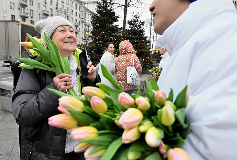 Волонтеры вручают цветы на Тверской площади