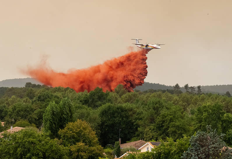 Пожарный самолет сбрасывает воду на очаг лесного пожара, Леж-Кап-Ферре, Франция