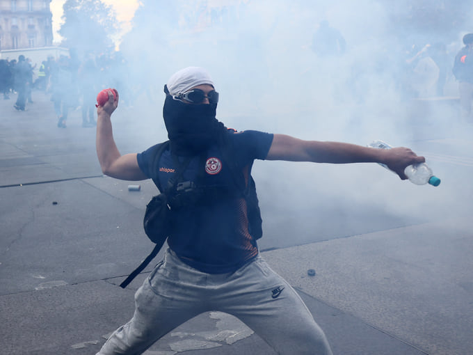 Протестующий в облаке слезоточивого газа