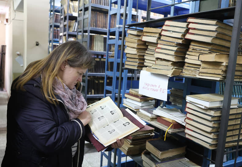 Посетитель выбирает книгу в хранилище