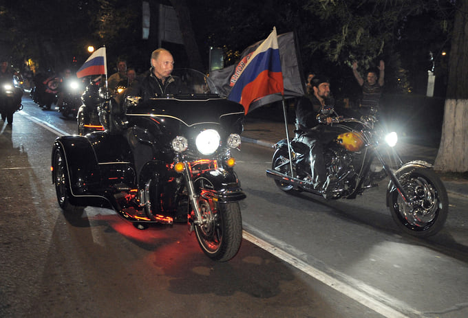 Владимир Путин сел за руль черного трехколесного мотоцикла Harley-Davidson и во главе байкерской колонны проехал к месту проведения шоу — крейсеру «Михаил Кутузов»