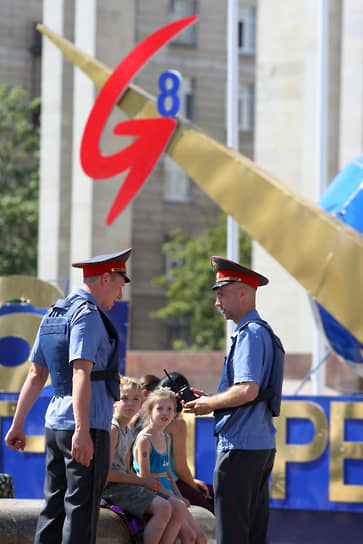 Сотрудники милиции на фоне символики саммита G8 на Московском проспекте 
