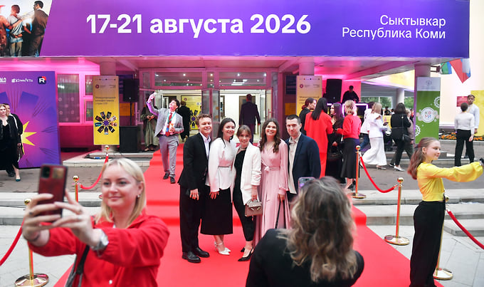 Горожане фотографируются на красной дорожке после прохода звезд