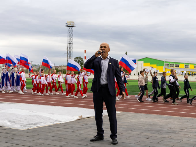 Участники торжественного шествия прошли по стадиону с российскими флагами
