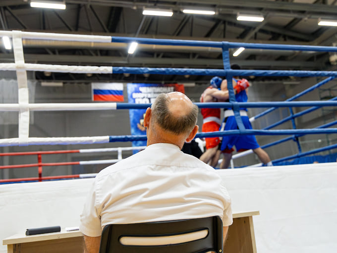 Судья наблюдает за поединком из-за ринга. Вместе с чемпионатом ВС РФ в Воронеже проходили соревнования юношей и юниоров. В общей программе участвовали более 200 боксеров